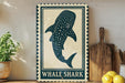 a decorative sign with a picture of a whale shark, placed on a wooden surface next to a wooden cutting board and some lemons.