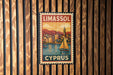 A vintage-style metal sign with the text "LIMASSOL" and "CYPRUS" printed on it, hanging on a wooden wall.