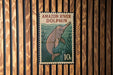 A poster of an Amazon River dolphin is displayed on a wooden wall.