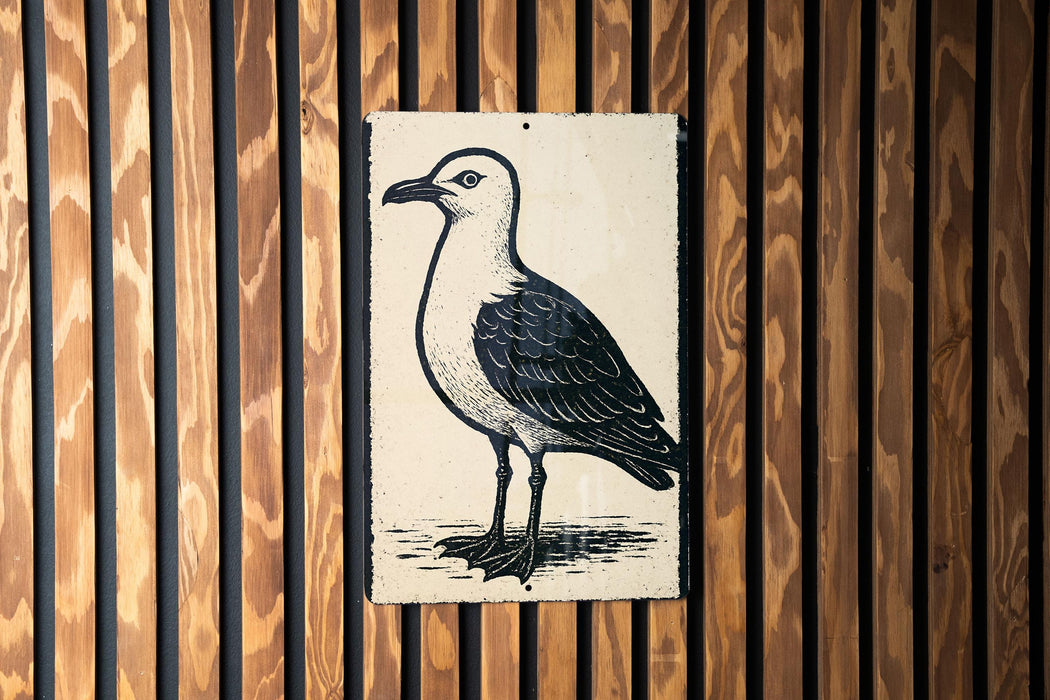 a black and white illustration of a bird, specifically a seagull, standing on one leg against a wooden background.