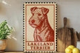 A vintage-style sign featuring a red and white illustration of a Lakeland Terrier dog, placed on a wooden surface next to a wooden cutting board and some lemons.