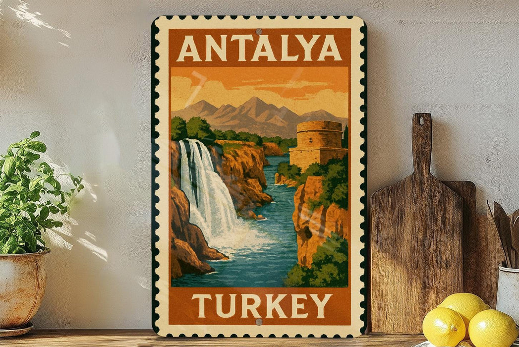 A vintage-style poster of Antalya, Turkey, featuring a waterfall and mountains, is displayed on a wall next to a wooden cutting board and a potted plant.