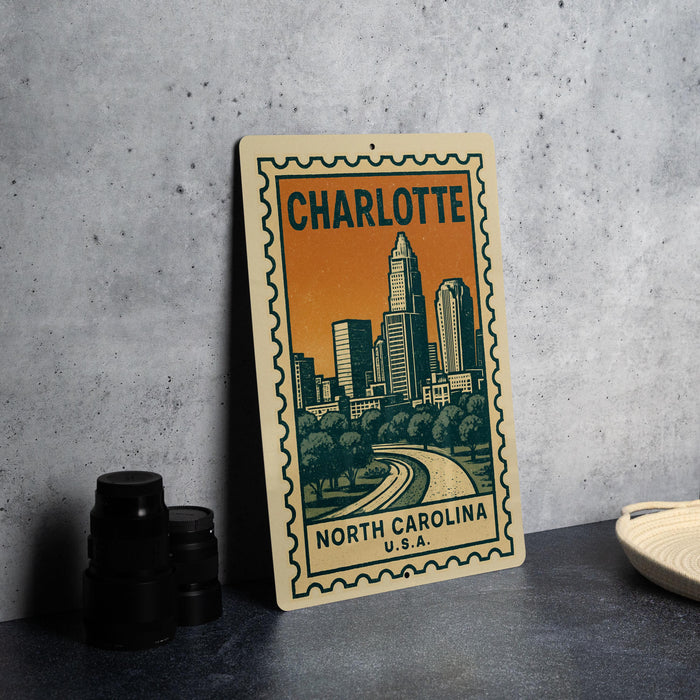 A metal sign with a cityscape illustration and the text "CHARLOTTE NORTH CAROLINA U.S.A."