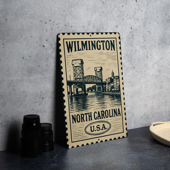 A metal sign with a drawing of a bridge and the text "WILMINGTON NORTH CAROLINA U.S.A."