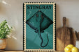 A framed illustration of a stingray is displayed on a shelf, accompanied by a wooden cutting board, a potted plant, and some lemons.