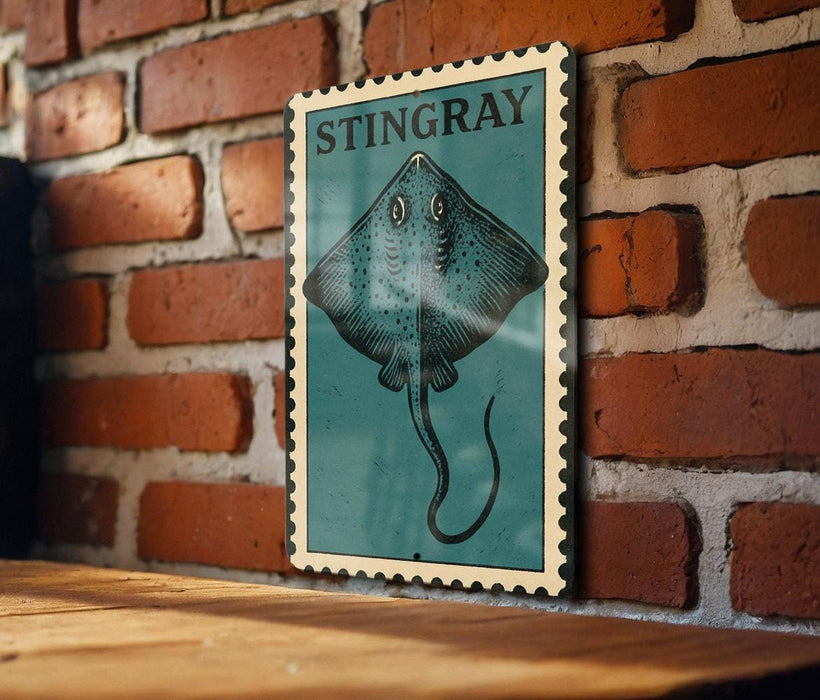 A framed illustration of a stingray is displayed on a brick wall.
