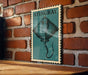 A framed illustration of a stingray is displayed on a brick wall.