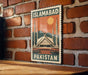 A poster of the Faisal Mosque in Islamabad, Pakistan, displayed on a brick wall.