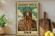 A vintage-style metal sign with the text "Sagrada Familia" and "SPAIN" printed on it, featuring an illustration of the Sagrada Familia church in Barcelona, Spain.