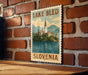 A vintage-style metal sign with the text "LAKELI BLED SLOVENIA" and an illustration of a church on a lake, mounted on a brick wall.