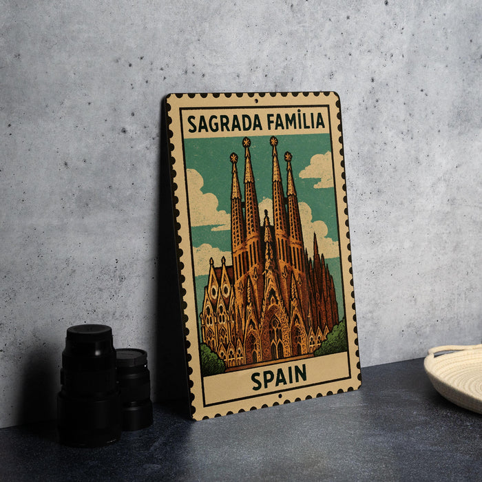 A metal sign with a colorful illustration of the Sagrada Familia, a famous Roman Catholic church in Barcelona, Spain.
