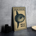 a metal sign with a picture of an ocean sunfish, labeled as "Mola Mola", placed on a table next to some black camera lenses.