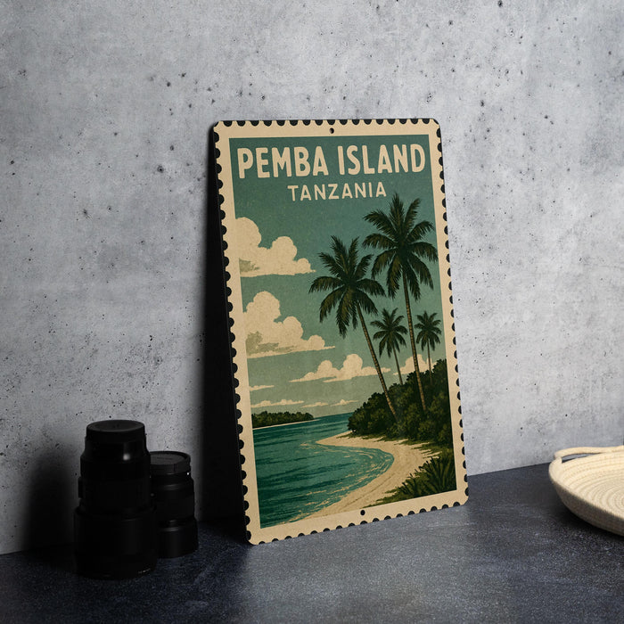 A vintage-style metal stamp depicting a tropical beach scene with palm trees and a calm ocean, placed on a gray surface next to some black camera lenses.