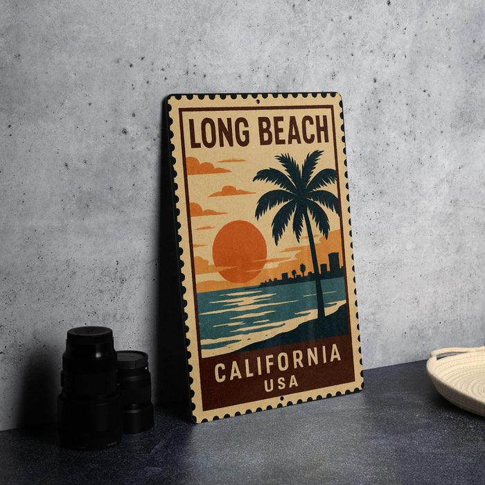 A vintage-style metal stamp depicting a sunset over the ocean, with a palm tree and the text "LONG BEACH, CALIFORNIA USA" printed on it.