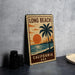 A vintage-style metal stamp depicting a sunset over the ocean, with a palm tree and the text "LONG BEACH, CALIFORNIA USA" printed on it.