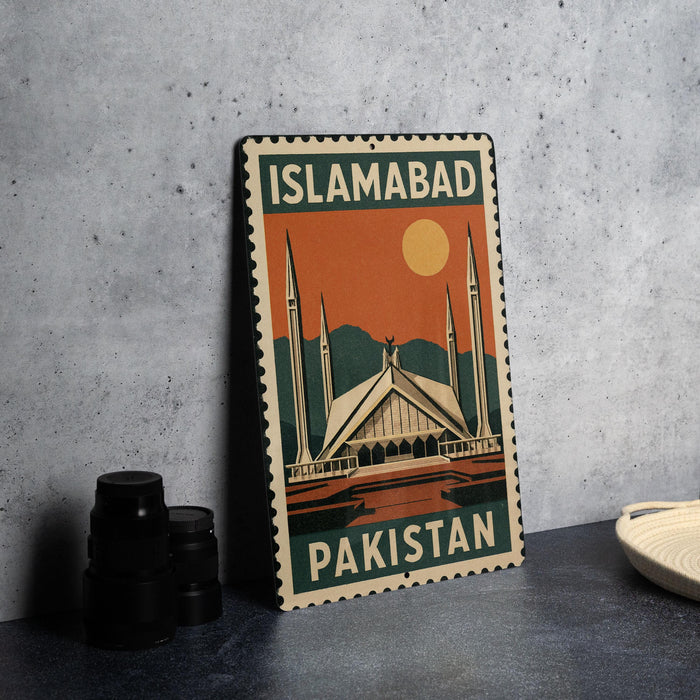A metal sign with the text "ISLAMABAD PAKISTAN" and an illustration of the Faisal Mosque, a famous landmark in Pakistan.