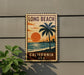 A vintage-style sign for Long Beach, California, featuring a palm tree and a sunset over the ocean.