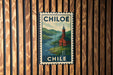 A vintage-style metal sign with a red building and a church steeple, mounted on a wooden wall.