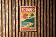 A vintage-style poster of a tropical beach scene with palm trees and a sunset, mounted on a wooden wall.