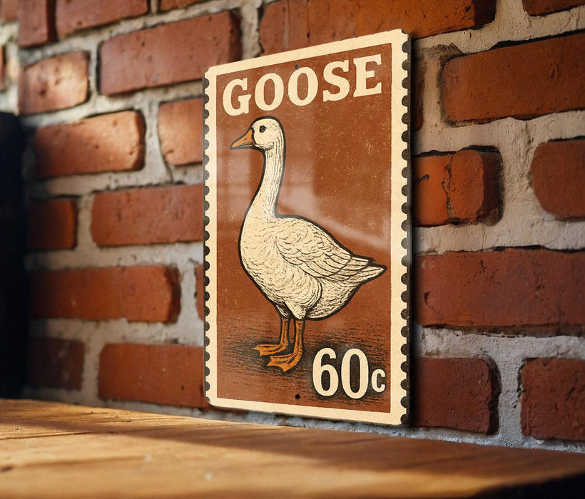 A vintage postage stamp featuring a white goose, with the text "GOOSE 60¢" printed on it, is displayed on a brick wall.