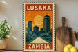 A vintage-style metal sign with the text "LUSAKA ZAMBIA" displayed prominently, featuring an illustration of a cityscape with a sunset in the background.
