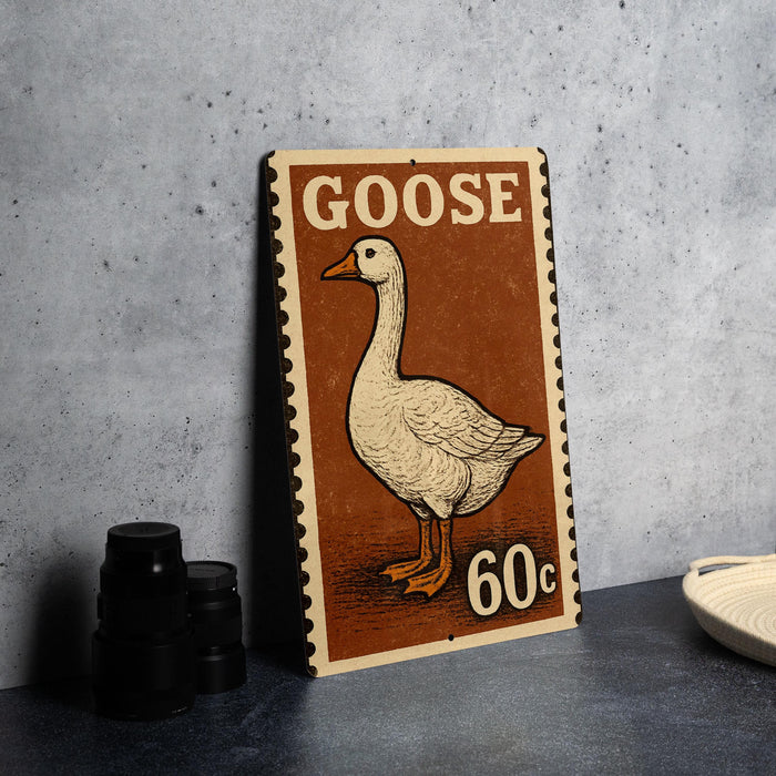 A vintage-style metal sign featuring a goose illustration and the text "GOOSE 60c" is displayed on a gray countertop.
