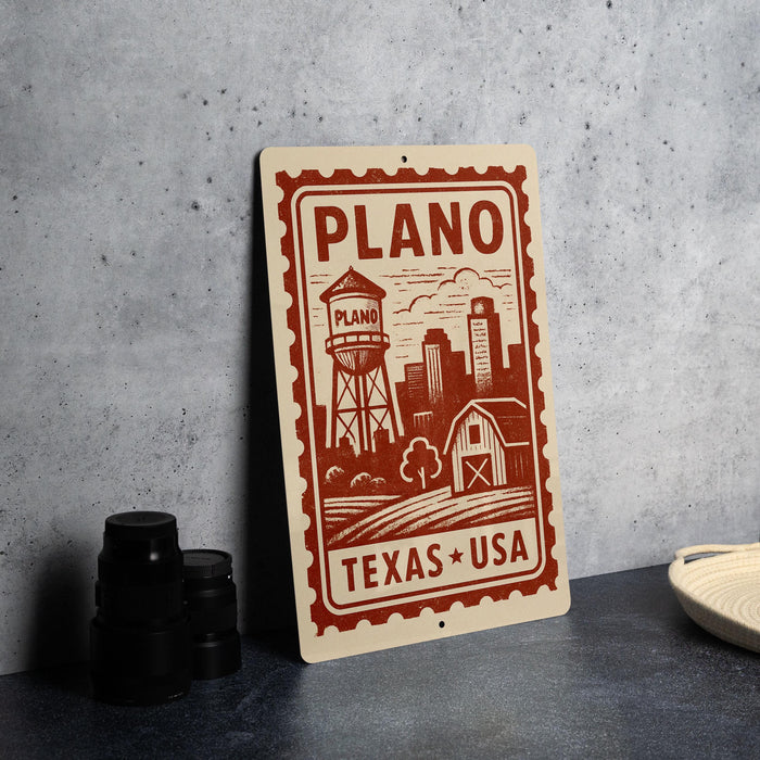 A sign for Plano, Texas, featuring a water tower and a barn, with the text "PLANO" and "TEXAS * USA" printed on it.