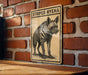 a sign with a striped hyena illustration on a brick wall.