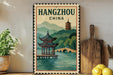 A vintage-style poster of a pagoda and a bridge in Hangzhou, China, displayed on a wall next to a wooden cutting board and some potted plants.