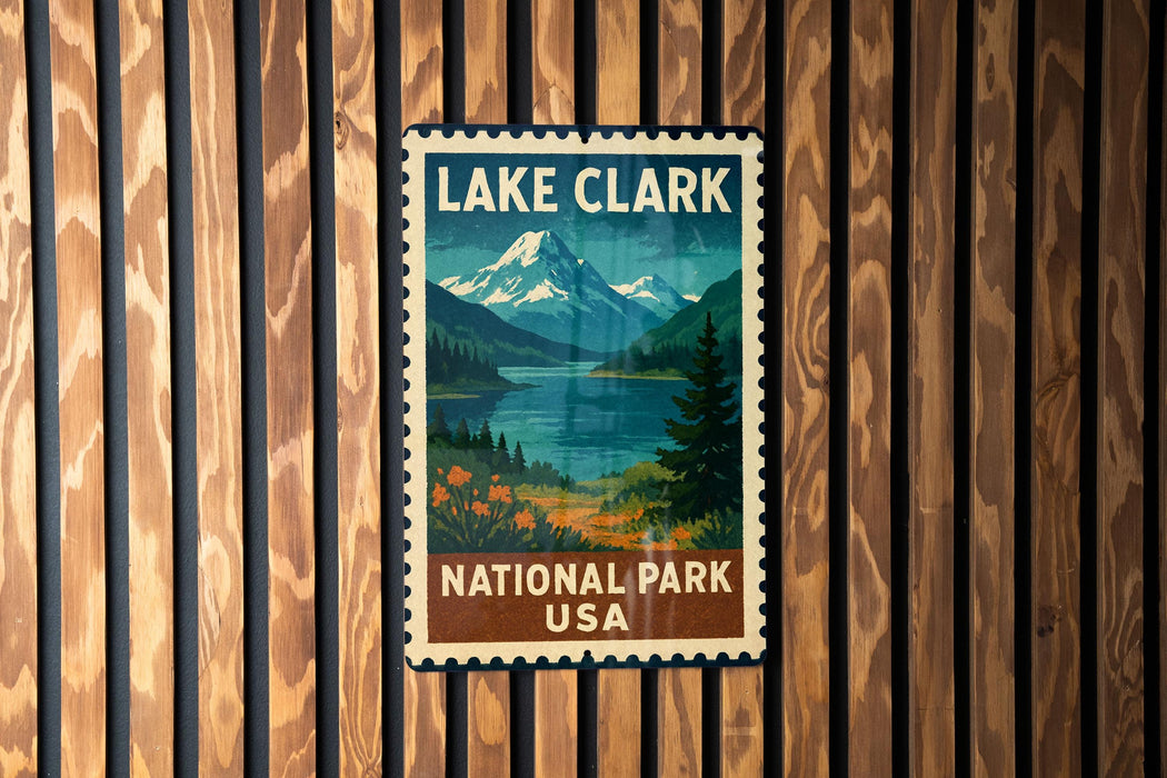 A vintage-style postage stamp featuring Lake Clark National Park in the USA, with a mountain landscape and a lake in the background.