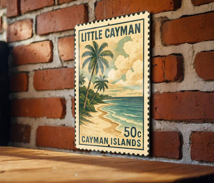 A framed vintage postage stamp depicting a tropical beach scene with palm trees and a sandy shoreline, hanging on a brick wall.
