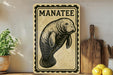 a manatee sign on a shelf, surrounded by kitchen utensils and a potted plant.