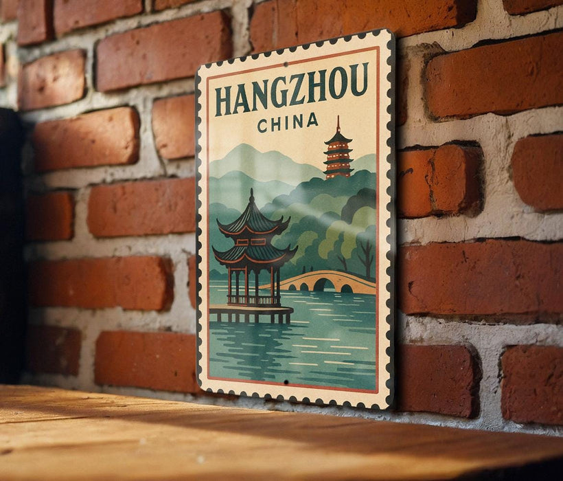 A vintage-style poster of Hangzhou, China, featuring a traditional Chinese pagoda and a serene body of water, mounted on a brick wall.