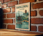 A vintage-style poster of Hangzhou, China, featuring a traditional Chinese pagoda and a serene body of water, mounted on a brick wall.