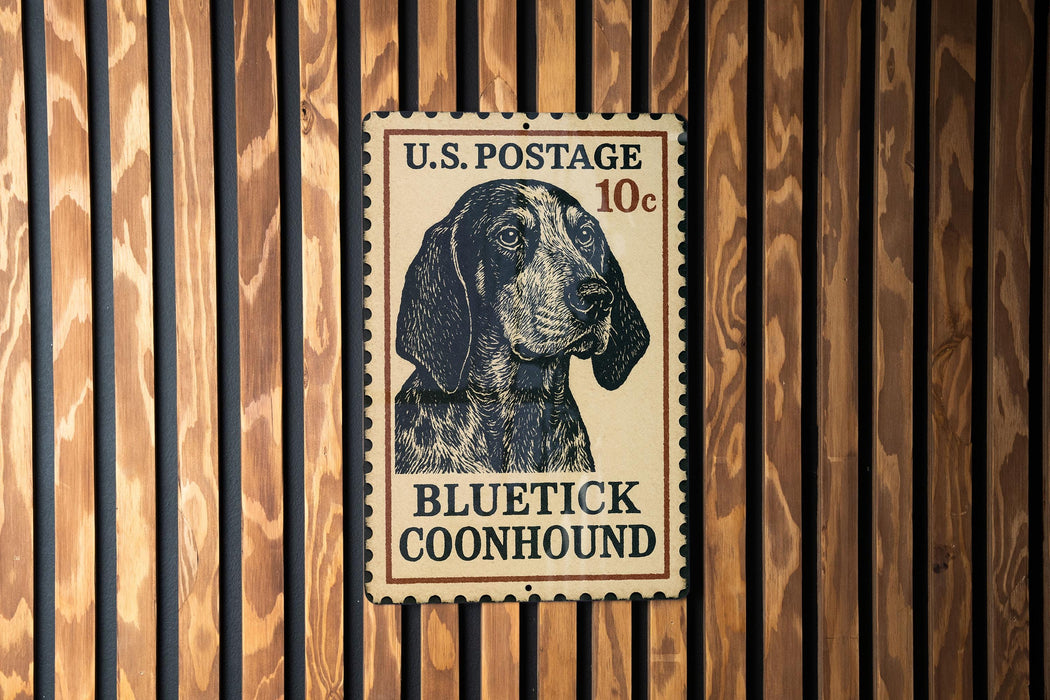 A U.S. postage stamp featuring a blue and black illustration of a blue and black dog, specifically a blue and black Coonhound, mounted on a wooden wall.