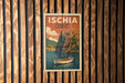 A vintage-style poster of Italy, featuring a small boat on the water and a picturesque coastal town, is displayed on a wooden wall.