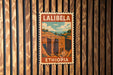 A vintage postage stamp from Ethiopia depicting a building, hanging on a wooden wall.
