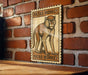 A wooden table with a wooden frame, and a framed illustration of a monkey on the wall.