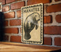A sign featuring a manatee, a large sea mammal, is displayed on a brick wall.