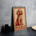 A framed illustration of a poodle is displayed on a wall, with a stack of black camera lenses next to it.