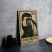 A 70 cent postage stamp featuring a close-up of a colobus monkey, placed on a dark surface next to some black camera lenses.