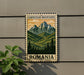 A metal sign with a mountain landscape and pine trees, mounted on a wall.