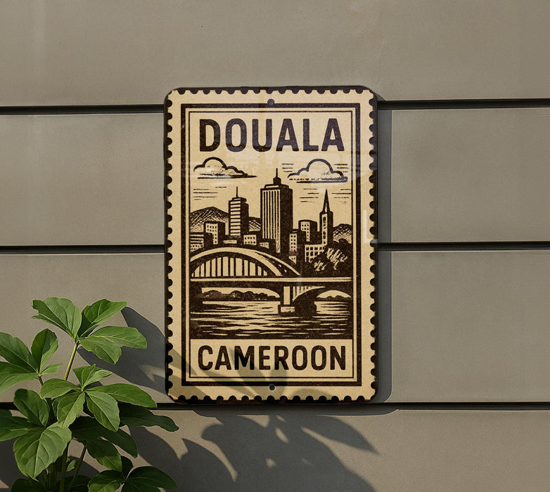 a sign that reads "DOUALA CAMERON" with a cityscape illustration on it.