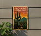 A vintage-style sign for Saguaro National Park in the United States, featuring a cactus landscape with a sunset in the background.