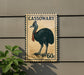 A postage stamp featuring a large black bird, possibly a cassowary, on a brown background.