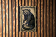 a wooden wall with a framed illustration of a raccoon.