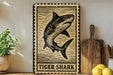 A framed image of a tiger shark is displayed on a shelf, accompanied by a wooden cutting board, a potted plant, and some lemons.