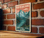 A vintage-style metal sign with a mountain landscape and a river, mounted on a brick wall.