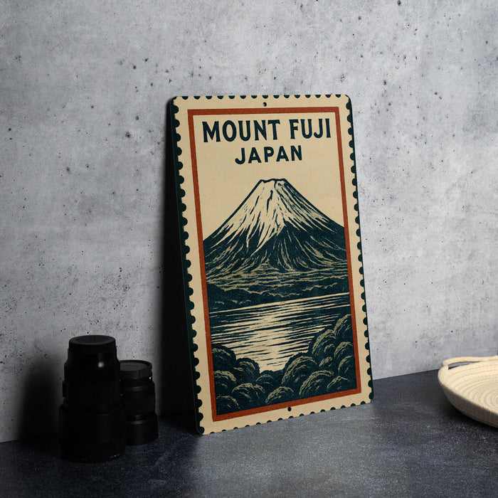 A framed poster of Mount Fuji, the famous Japanese volcano, is displayed on a wall next to a stack of black camera lenses.