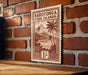 a wooden sign with a tropical island landscape, mounted on a brick wall.